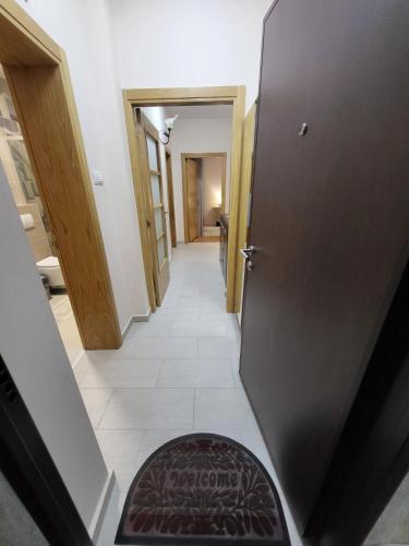 a hallway with a door and a rug on the floor at Centre Podgorica apartment in Podgorica