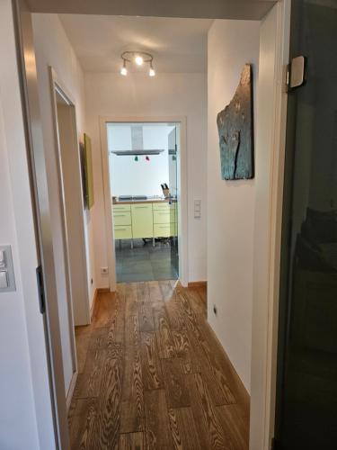 a hallway leading into a kitchen with a hallway leading into a house at Residence Moai - Exklusiver Rückzugsort für Geschäftsreisen - kostenloser Parkplatz, WLAN, Waschtrockner, Smart TV, Qbo ESSENTIAL, ergonomischer Schreibtisch in Erlangen