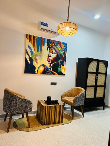 a room with two chairs and a painting on the wall at Leparadis Zanzibar Boutique Hotel in Jambiani