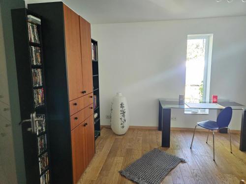 a room with a desk and a table and a book shelf at Residence Moai - Exklusiver Rückzugsort für Geschäftsreisen - kostenloser Parkplatz, WLAN, Waschtrockner, Smart TV, Qbo ESSENTIAL, ergonomischer Schreibtisch in Erlangen