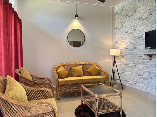 a living room with wicker chairs and a mirror at Sunny Villa in Sivasagar