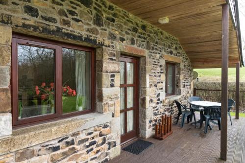 a stone house with a patio with a table and chairs at The Lodge at Horton Hall Retreat in Skipton