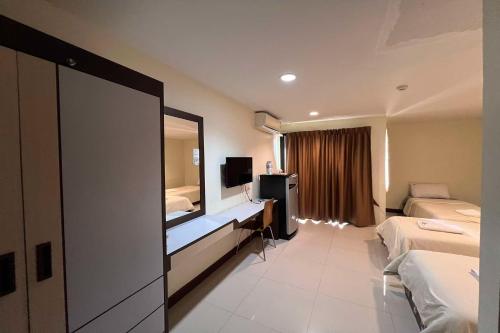 a hotel room with two beds and a television at The Nine Place in Ban Kohong