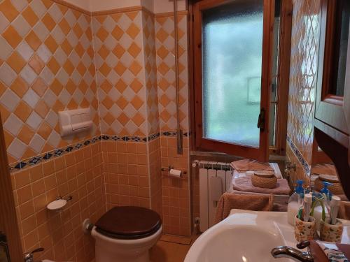 ein Badezimmer mit Toilette und Waschbecken und einem Fenster in der Unterkunft Home & Garden in Castel di Sangro