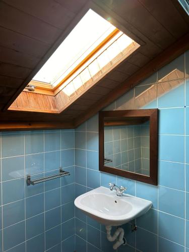 a bathroom with a sink and a skylight at Casa Entre-Palheiros e Casa do Canastro in Montalegre