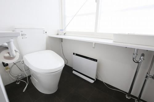 a white bathroom with a toilet and a sink at TR Niseko House Room Lavender in Niseko