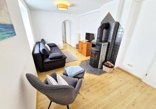 Una sala de estar con un sofá y una chimenea. en Entzückende Traumwohnung - nur 5min vom Europa-Park!, en Rheinhausen