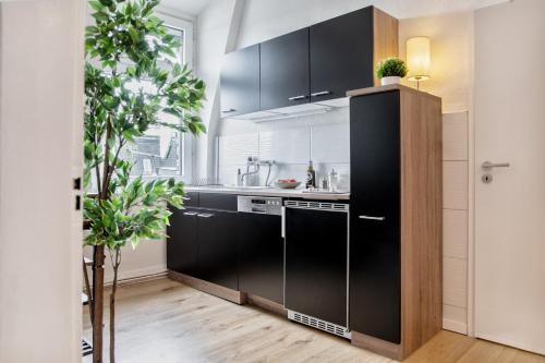 eine Küche mit schwarzen Schränken und einer Spüle in der Unterkunft stayVision FS43 Wohnung 7 - 1 Schlafzimmer - 4 Gäste - top WLAN in Wuppertal