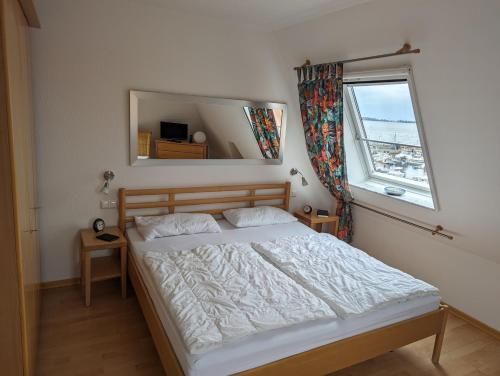 ヴィーク・アウフ・リューゲンにあるFerienwohnung An de Waterkant Wiekのベッドルーム1室(窓、鏡付)