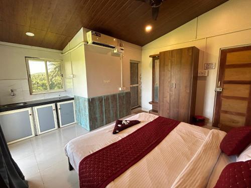 a bedroom with a large bed and a kitchen at Shivam Bnb Mandrem Resort in Mandrem