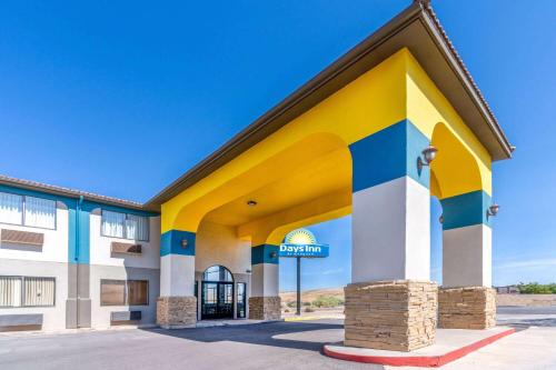 a building with a yellow and blue at Days Inn by Wyndham Los Lunas in Los Lunas