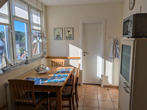 ヴィーク・アウフ・リューゲンにあるFerienwohnung An de Waterkant Wiekのテーブルと椅子、冷蔵庫のあるキッチン
