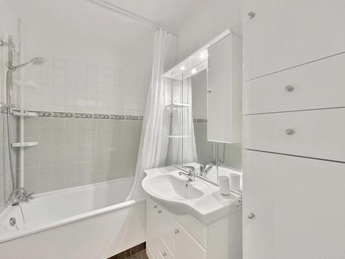 La salle de bains blanche est pourvue d'un lavabo et d'une baignoire. dans l'établissement CL124 Studio cabine cosy 4 pers centre, aux Carroz d'Arâches