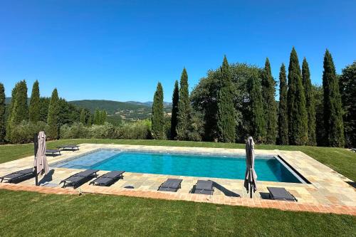 a swimming pool in a yard with chairs and trees at Villa San Vicenzo by Mmega in Calzolaro