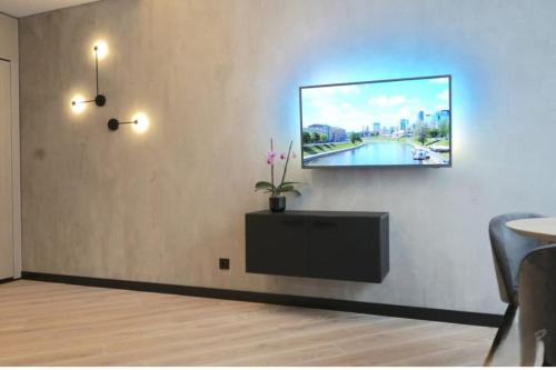 a living room with a tv on a wall at HaPPy Inn Exclusive studio, Self check in, Parking in Vilnius