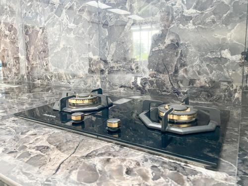 a kitchen with two stove tops on a counter at RedDoorz Syariah at Prisma Homestay in Kalianget