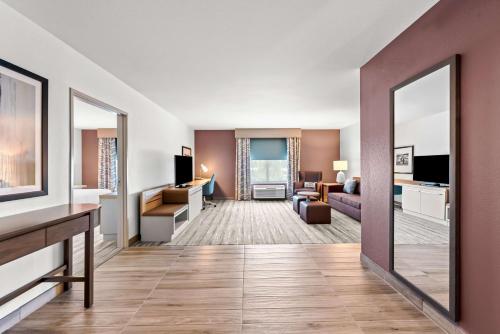 a living room with a large mirror in a hotel room at Hilton Garden Inn Seattle North/Everett in Mukilteo
