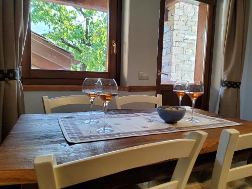 a wooden table with glasses of wine on it at La Vigne de Papagran in Aosta