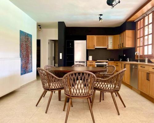 a kitchen with a table and chairs in a room at Villa G in Anavissos