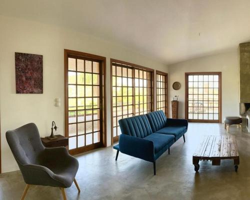 a living room with a couch and chairs and a table at Villa G in Anavissos