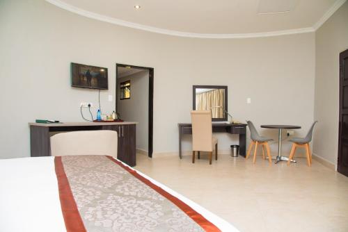 a bedroom with a bed and a table and chairs at Sunbird Nkopola in Chipoka