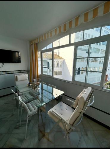 a living room with a glass table and chairs at Apto Laguna con piscina in El Portil