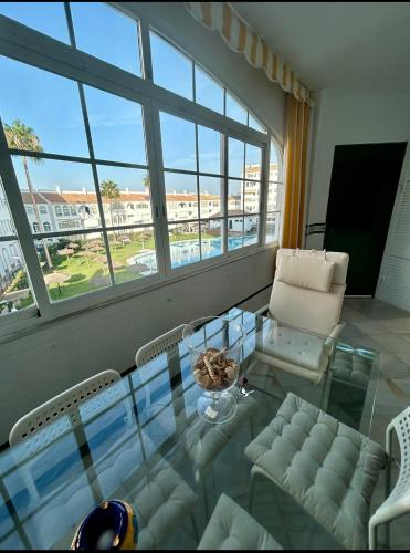 a living room with a glass table and a couch at Apto Laguna con piscina in El Portil
