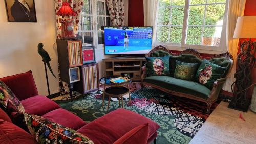 a living room with a couch and a flat screen tv at Hôtel Saint Jacques in Thorigné-sur-Dué