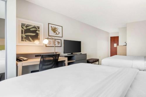 a hotel room with a bed and a desk with a computer at Country Inn & Suites by Radisson, Dayton South, OH in Dayton