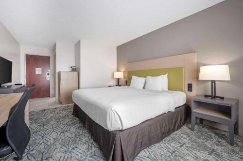 a hotel room with a large bed and a desk at Country Inn & Suites by Radisson, Dayton South, OH in Dayton
