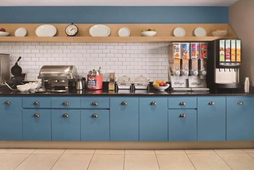 a kitchen with blue cabinets and a counter top at Country Inn & Suites by Radisson, Dayton South, OH in Dayton