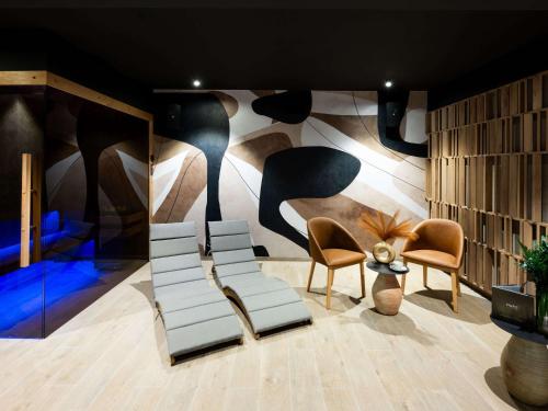 a room with chairs and a wall with a mural at Mercure Szczyrk Resort in Szczyrk