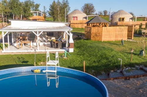 a swimming pool in a yard with a gazebo at Osada JurtCamp w Witowie in Witówko