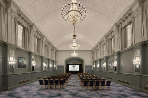a large room with chairs and a projection screen at DoubleTree By Hilton Brighton Metropole in Brighton & Hove