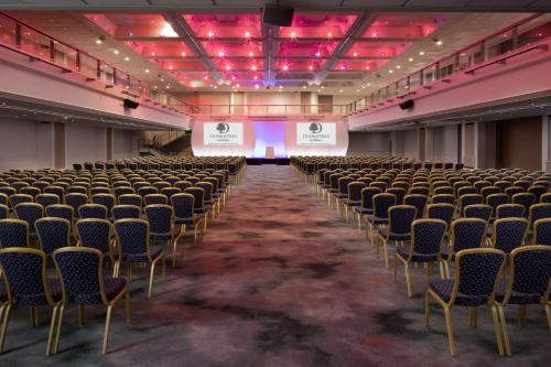 an empty lecture hall with chairs and a stage at DoubleTree By Hilton Brighton Metropole in Brighton & Hove