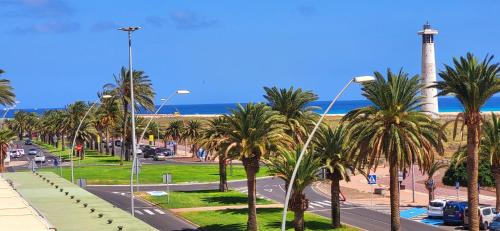 a view of a street with palm trees and the ocean at Ferienwohnung Sol, Morro Jable, Meerblick, Klimaanlage, Pool in Morro del Jable