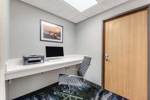 a room with a desk with a computer and a door at Comfort Inn & Suites Weston - Wausau in Weston