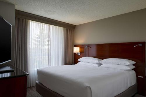 a bedroom with a large white bed with a window at DoubleTree by Hilton Minneapolis Airport, MN in Bloomington