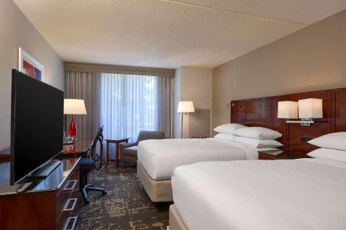 a hotel room with two beds and a flat screen tv at DoubleTree by Hilton Minneapolis Airport, MN in Bloomington
