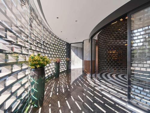 a hallway with a brick wall and a vase with flowers at Hilton Garden Inn Xi'An Bell Tower in Xi'an
