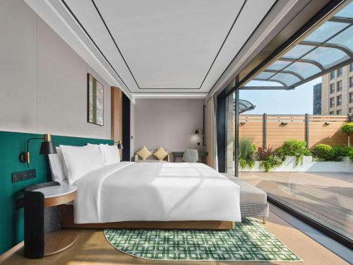 a bedroom with a large bed and a large window at Hilton Garden Inn Xi'An Bell Tower in Xi'an