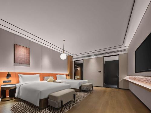 a bedroom with two beds and a flat screen tv at Hilton Garden Inn Xi'An Bell Tower in Xi'an