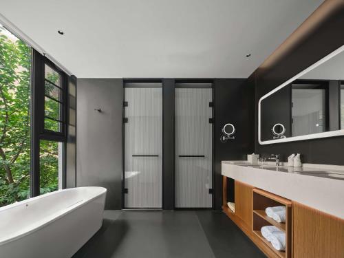 a bathroom with a white tub and a sink at Hilton Garden Inn Xi'An Bell Tower in Xi'an