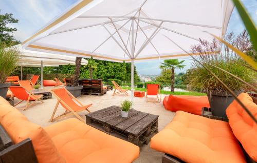 a patio with orange chairs and an umbrella at Mercure Hotel Bielefeld Johannisberg in Bielefeld