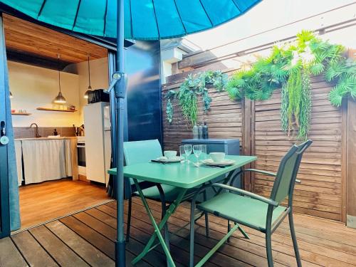 a table and chairs with an umbrella on a patio at Villa Moai 974 in Saint-Leu