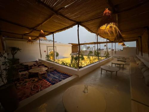 a large room with tables and a view of a patio at Riad Ait El Mouden in Agadir