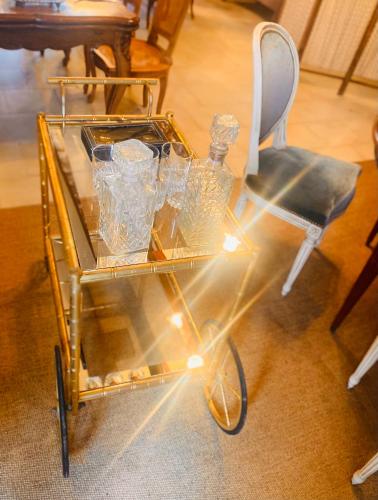 une charrette en or avec des lunettes à côté d'une chaise dans l'établissement Auberge du chant du coq, à Anjouin