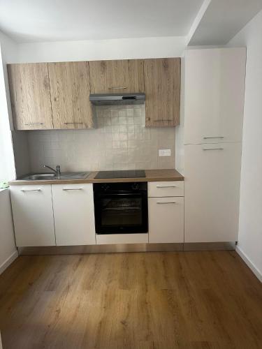 une cuisine avec des armoires blanches et un four noir dans l'établissement Dar Noailles - Central apartment near to Vieux-port, à Marseille