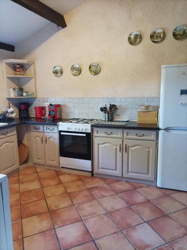 Il comprend une cuisine équipée d'une cuisinière et d'un réfrigérateur blanc. dans l'établissement Teyssie Cottage, à Pailloles