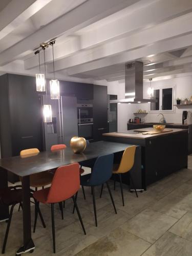 une cuisine avec une table et des chaises dans une pièce dans l'établissement Villa avec piscine à proximite de la plage 10 pers, à Ondres